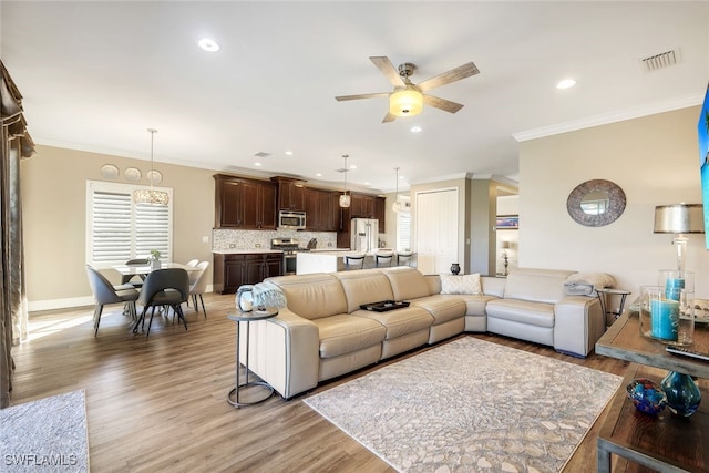 living room featuring ceiling fan, wood-type flooring, and crown molding