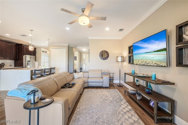 living room featuring dark hardwood / wood-style flooring, ceiling fan, and ornamental molding