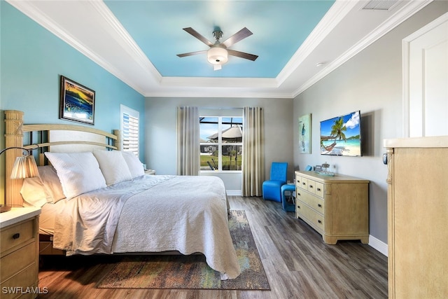 bedroom featuring a raised ceiling, ceiling fan, dark hardwood / wood-style flooring, and crown molding