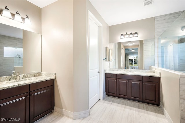 bathroom with vanity and tiled shower