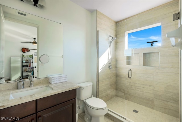 bathroom featuring ceiling fan, vanity, an enclosed shower, and toilet