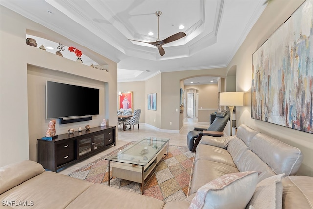 living room with a tray ceiling, ceiling fan, and ornamental molding