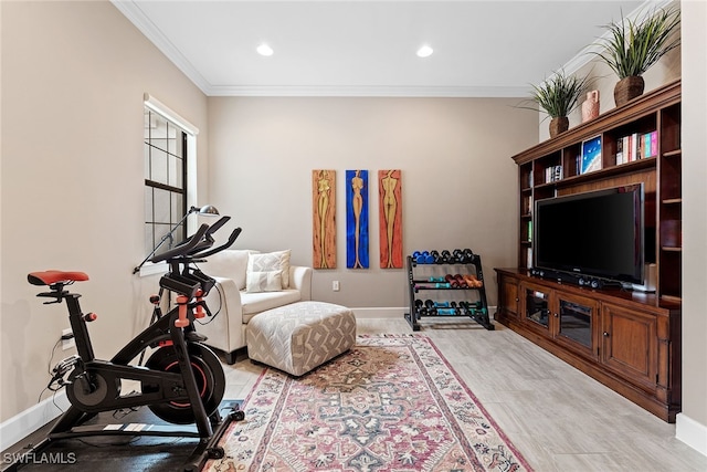 workout room with light hardwood / wood-style flooring and crown molding