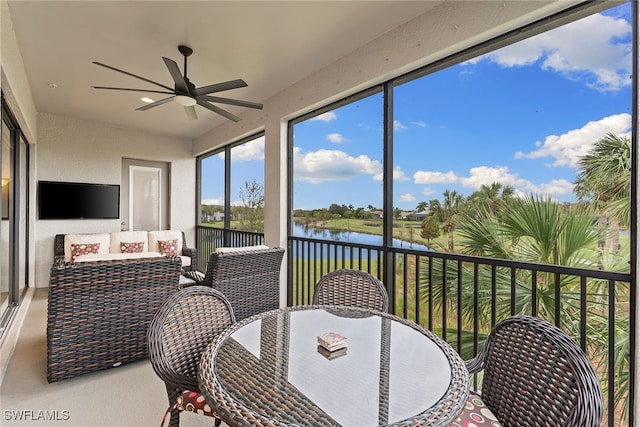 sunroom with a water view and ceiling fan