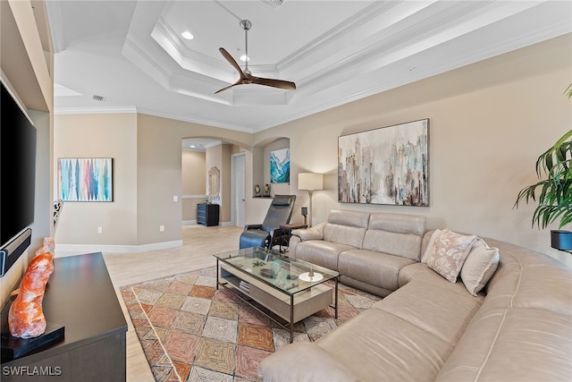 living room with hardwood / wood-style floors, a raised ceiling, ceiling fan, and crown molding