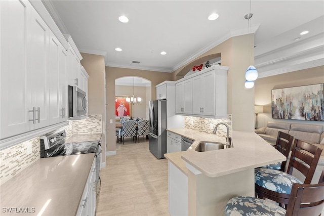 kitchen with a breakfast bar area, sink, pendant lighting, and appliances with stainless steel finishes