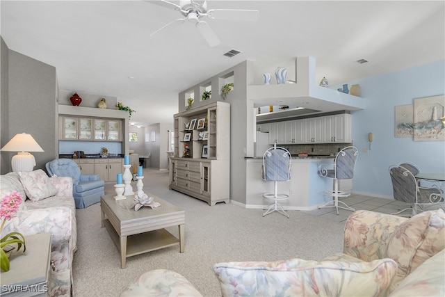 living room with ceiling fan and light colored carpet