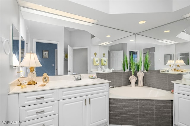 bathroom featuring vanity and a relaxing tiled tub