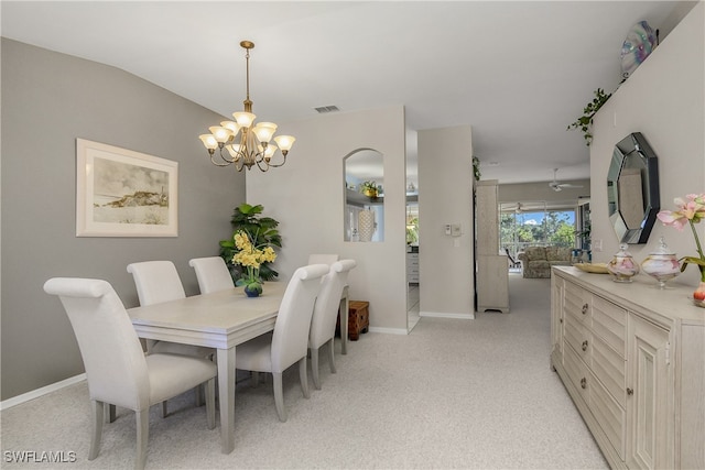 dining space featuring light carpet, vaulted ceiling, and an inviting chandelier