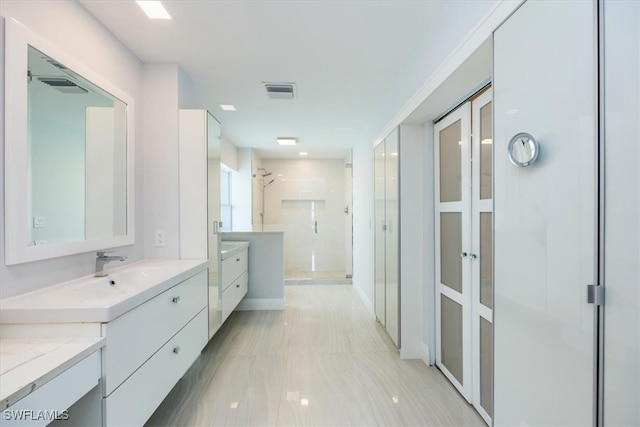 bathroom featuring vanity and a shower with door