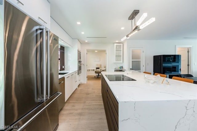 kitchen featuring light wood-type flooring, white cabinetry, and appliances with stainless steel finishes