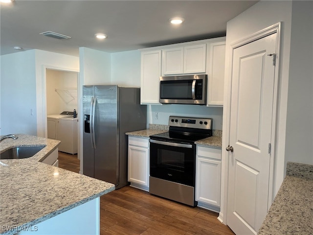 kitchen with light stone countertops, sink, white cabinets, and stainless steel appliances