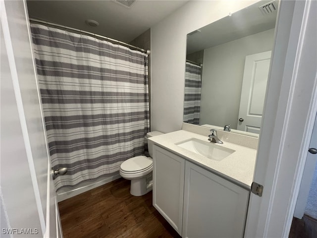 full bathroom with shower / bath combo with shower curtain, hardwood / wood-style floors, vanity, and toilet