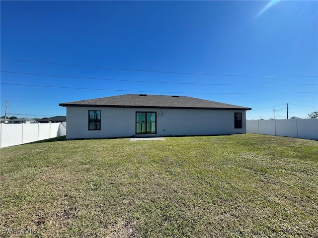 rear view of property with a yard