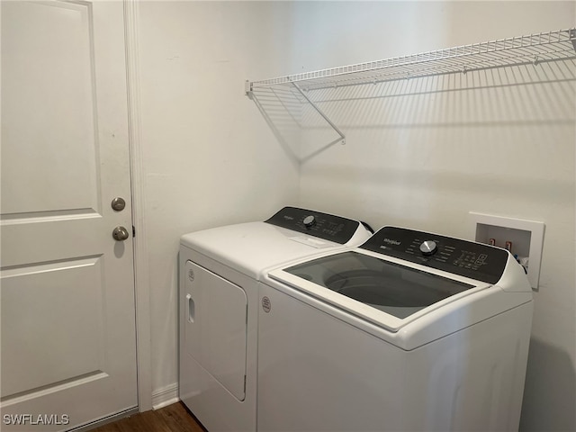 laundry area with washer and dryer and dark wood-type flooring