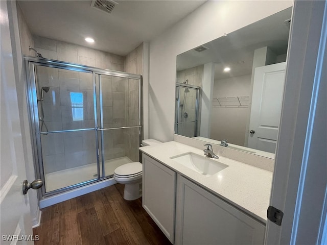 bathroom featuring walk in shower, toilet, vanity, and hardwood / wood-style flooring