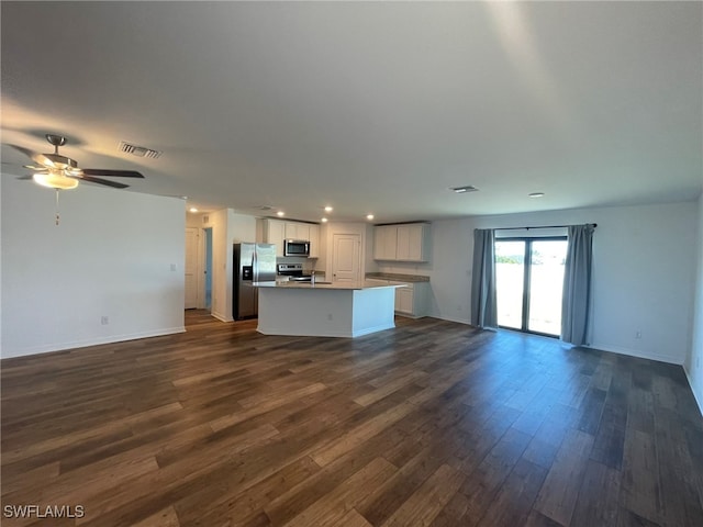 unfurnished living room with ceiling fan and dark wood-type flooring