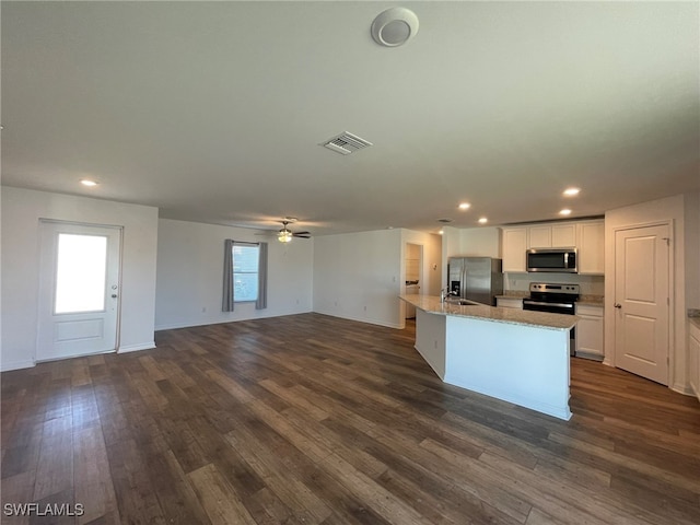 kitchen with white cabinetry, sink, dark wood-type flooring, a center island with sink, and appliances with stainless steel finishes