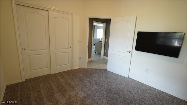 unfurnished bedroom featuring carpet and a closet