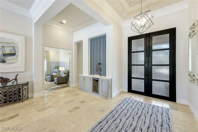 entryway with wine cooler, crown molding, french doors, and an inviting chandelier