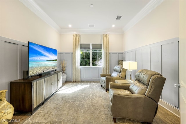 sitting room with hardwood / wood-style flooring and ornamental molding