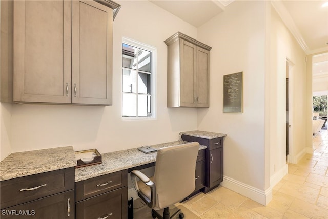 home office with built in desk and ornamental molding