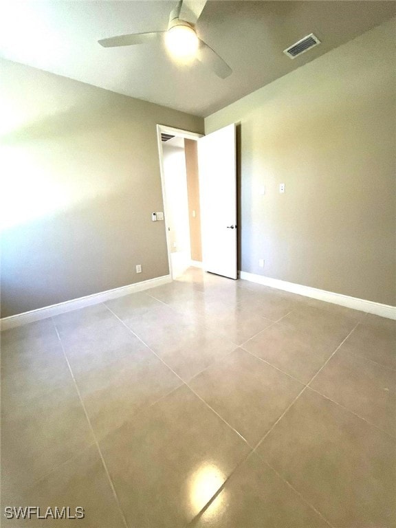 spare room featuring ceiling fan and light tile patterned flooring