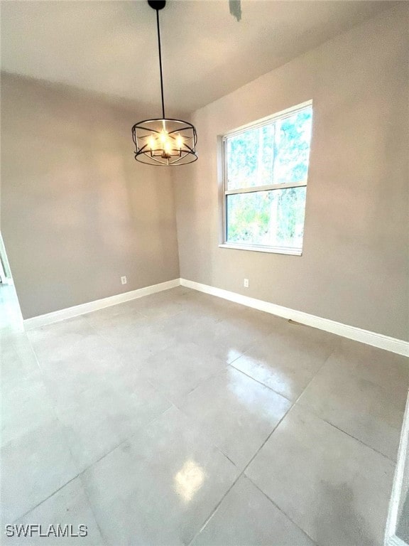 unfurnished room with a chandelier