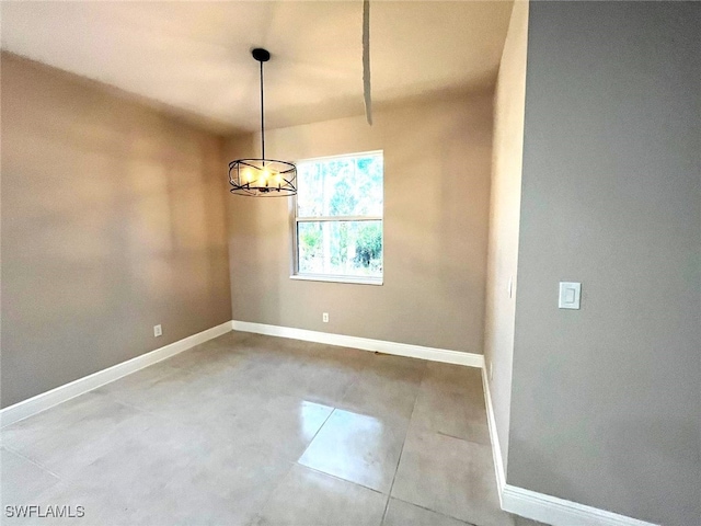 unfurnished dining area featuring tile patterned flooring and an inviting chandelier