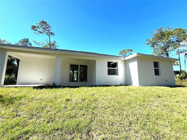 rear view of house featuring a yard