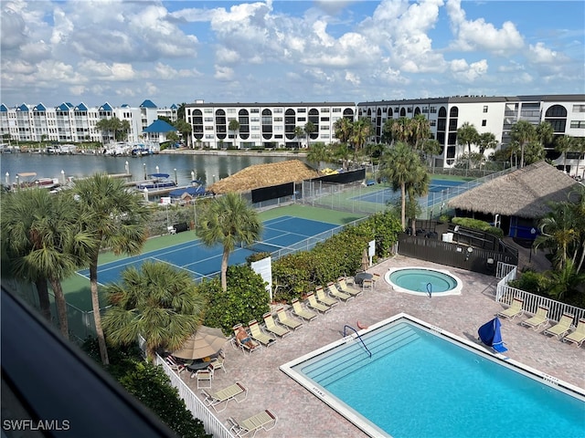 view of pool featuring a water view and a patio