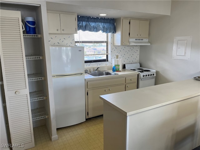 kitchen featuring kitchen peninsula, white appliances, tasteful backsplash, and sink