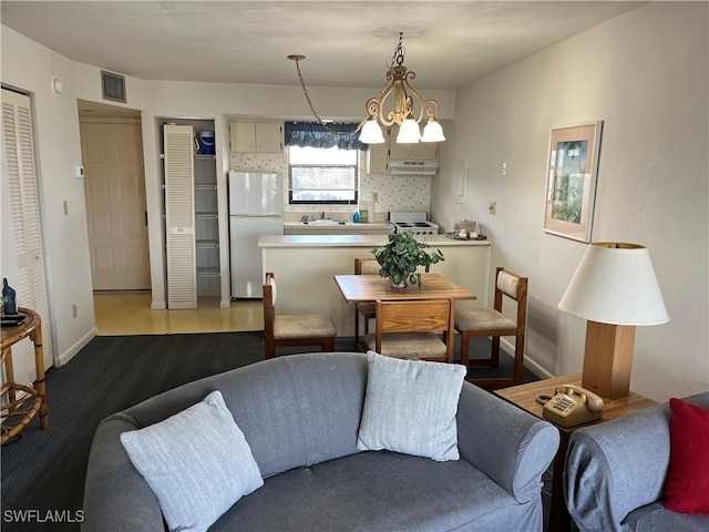 living room featuring sink, light hardwood / wood-style floors, and an inviting chandelier