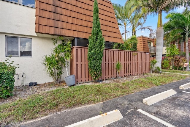 5260 Cedarbend Dr SW Unit 4, Fort Myers, FL 33919 - view of property exterior with stucco siding, uncovered parking, a tiled roof, and mansard roof