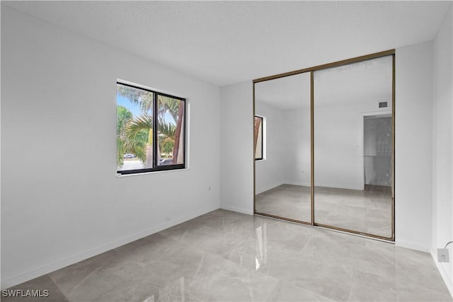 unfurnished bedroom with a closet and a textured ceiling