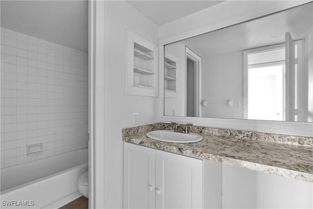 full bathroom with vanity, toilet, and tiled shower / bath