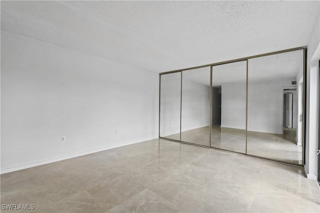 unfurnished bedroom featuring a textured ceiling and a closet