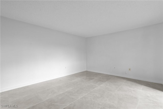 unfurnished room featuring a textured ceiling