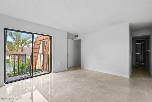 unfurnished room featuring a textured ceiling