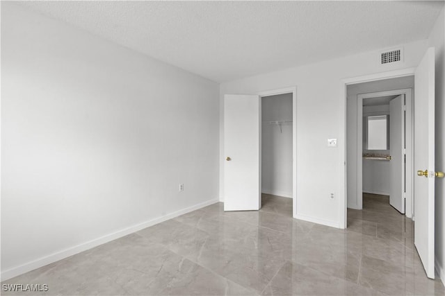 unfurnished bedroom with a textured ceiling and a closet