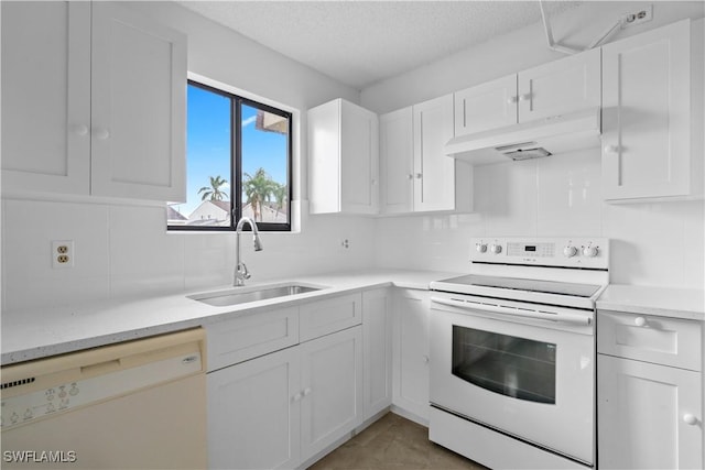 kitchen featuring a textured ceiling, white cabinetry, sink, and white appliances