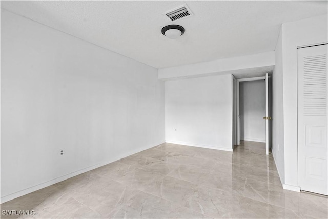 unfurnished room featuring a textured ceiling