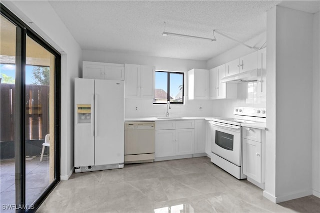 kitchen with sink, a textured ceiling, white appliances, and custom exhaust hood