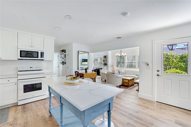 kitchen with white cabinets, electric range, and light hardwood / wood-style floors