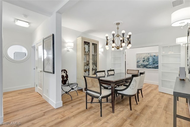 dining room featuring light hardwood / wood-style flooring and a notable chandelier