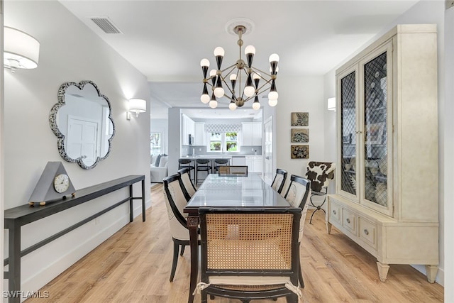 dining room with a notable chandelier and light hardwood / wood-style flooring