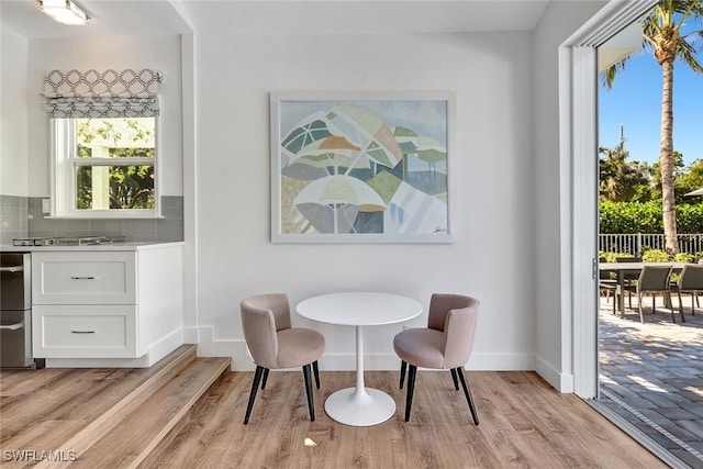 dining room with light wood-type flooring and a healthy amount of sunlight