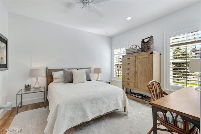 bedroom with light hardwood / wood-style floors, multiple windows, and ceiling fan