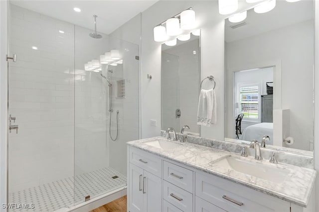 bathroom with hardwood / wood-style floors, vanity, and tiled shower