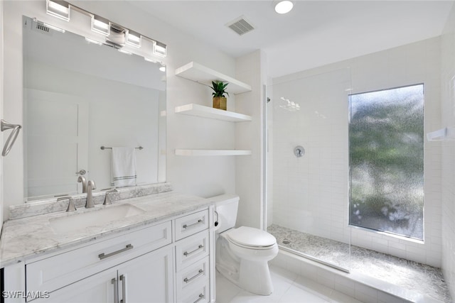 bathroom featuring tiled shower, tile patterned flooring, toilet, and a healthy amount of sunlight